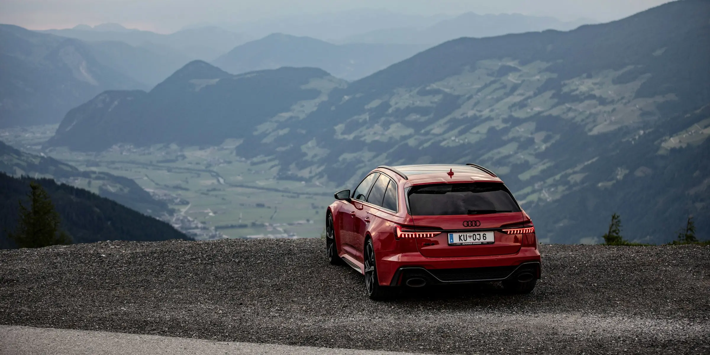 Roter Audi vor einem Bergpanorama