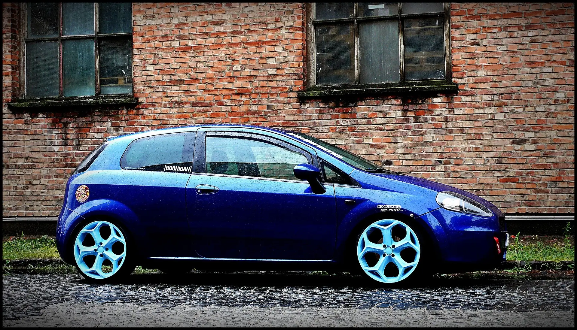 Blauer Fiat Bravo vor einer Backsteinmauer